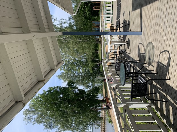 Terassi, jossa kahvilapöydät.Aurinkoinen päivä.